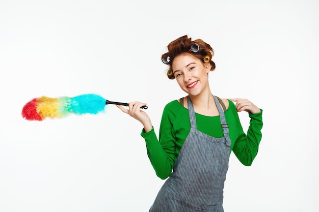 Free photo cool housewife smiles  holding duster in hands