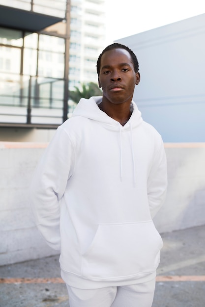 Free photo cool man in white hoodie and sweatpants men's fashion apparel shoot
