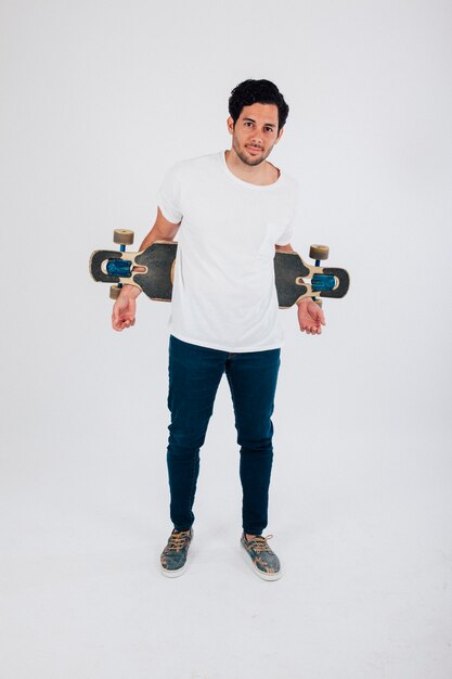 그의 등 뒤에 longboard와 멋진 남자