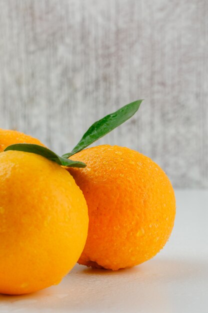 Cool oranges with leaves, close-up.