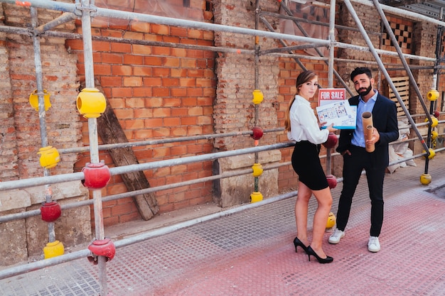 Free photo cool real estate agents posing with scaffold