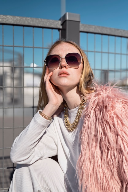 Cool woman posing with sunglasses medium shot