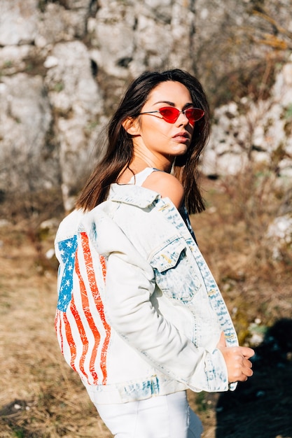 Cool young woman in denim jacket and sunglasses