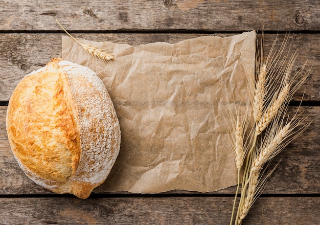 Copy space baking paper with round bread and wheat