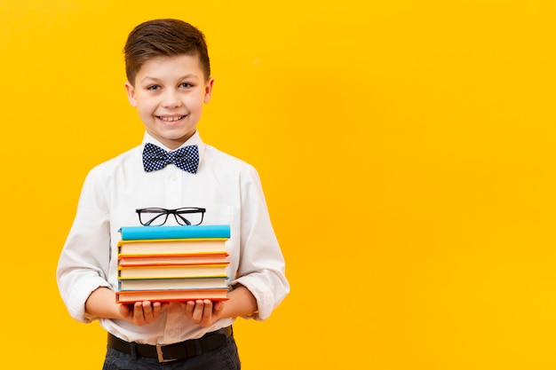 Free photo copy-space boy holding stack of books