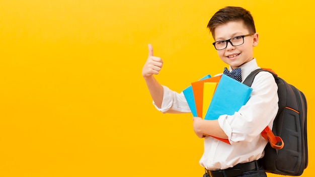 Copy-space boy with books showing ok sign