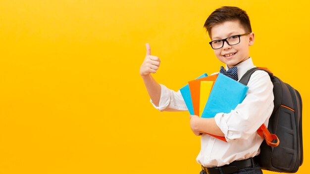 Copy-space boy with books showing ok sign