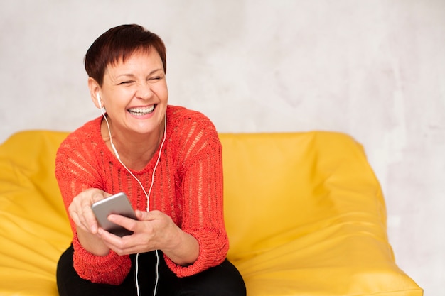 Copy-space elder woman listening music