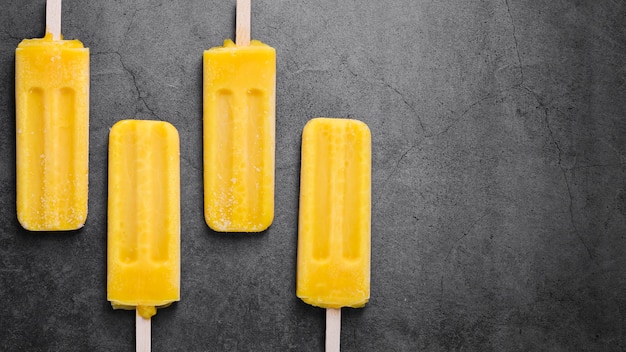 Copy-space ice cream on sticks aligned on table