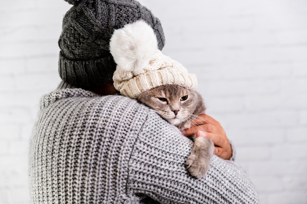 Copy-space male and cat wearing fur cap