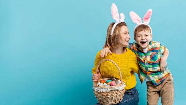 Free photo copy-space smiley boy and mom with painted eggs