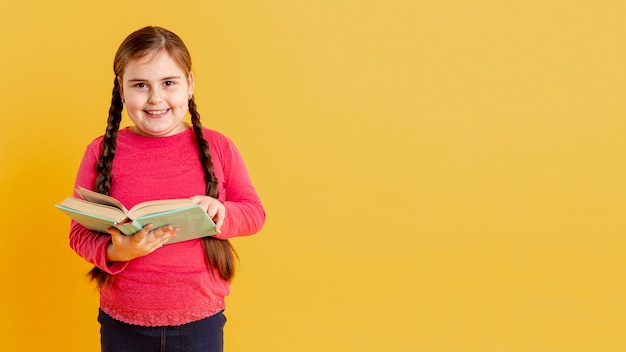 Free photo copy-space smiley girl reading