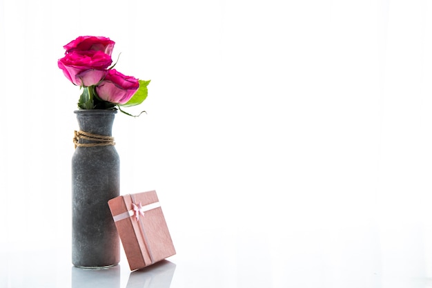 Foto gratuita copia spazio vaso di rose con regalo