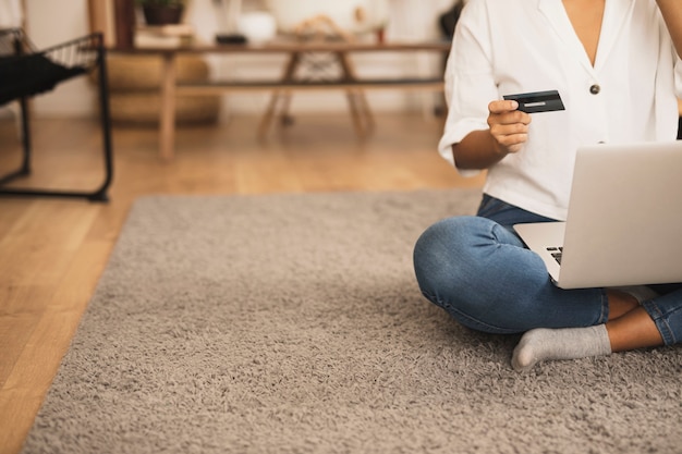 Copy space woman holding a credit card on floor