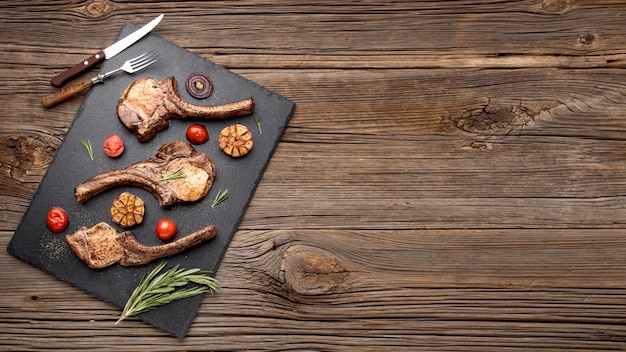 Free photo copy-space wooden board with cooked meat