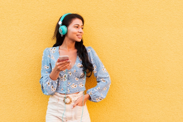 Copy space yellow background with woman and headphones