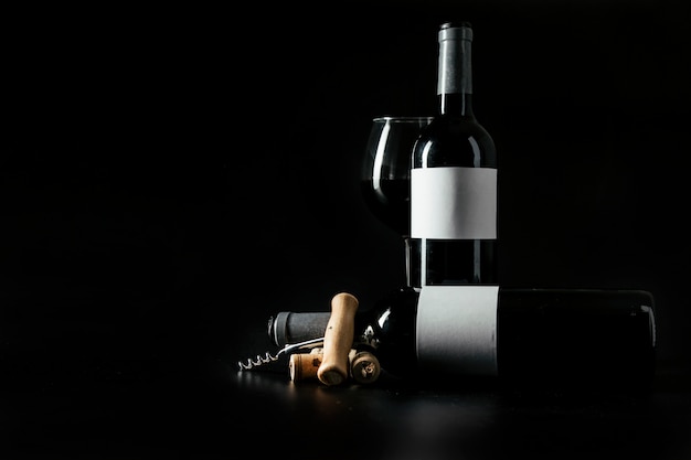 Free photo corkscrew and corks near bottles and wineglass