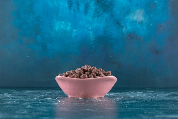 Foto gratuita palline di mais in una ciotola sulla superficie blu