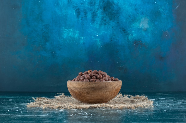 Free photo corn balls in a bowl on a towel , on the blue table.