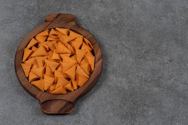 Corn chips and dried bread on the wooden tray  on the marble surface