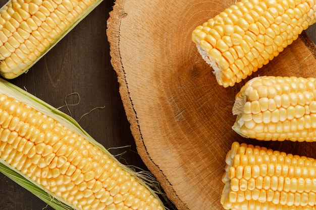 Corn cobs on a wooden piece on a wooden table. flat lay.