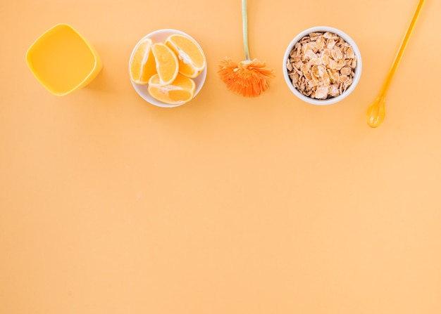 Corn flakes in bowl with orange and juice