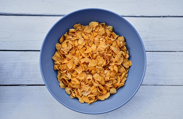 Corn flakes in a plate on a wooden desk. Food concept