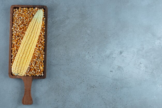 Бесплатное фото Завод кукурузы на коричневой фасоли на деревянном блюде. фото высокого качества