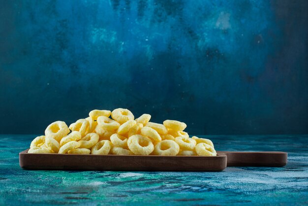 Corn rings in a board on the blue surface