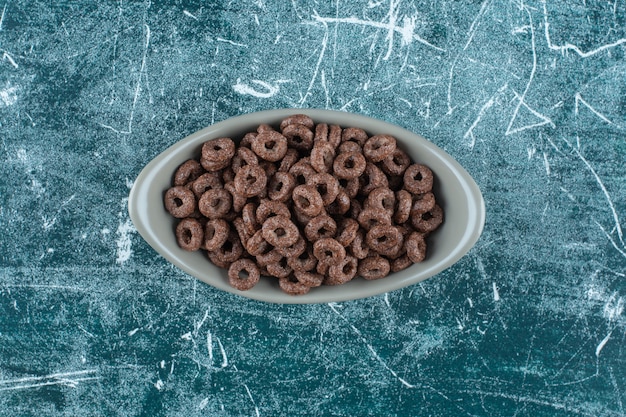 Free photo corn rings in a bowl , on the blue background. high quality photo