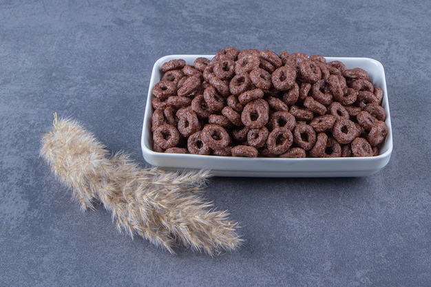 Corn rings in a bowl next to pampas grass, on the marble background. High quality photo