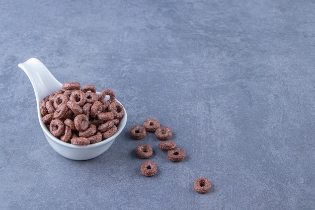 Free photo corn rings in a spoon , on the marble background.