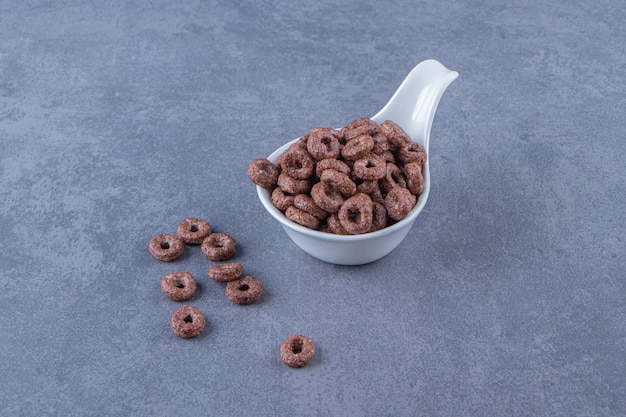 Corn rings in a spoon , on the marble background.