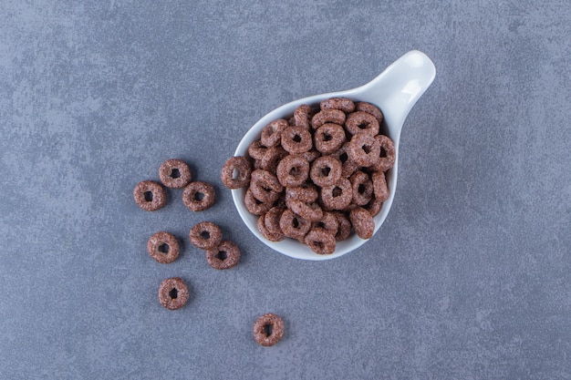 Free photo corn rings in a spoon, on the marble table.