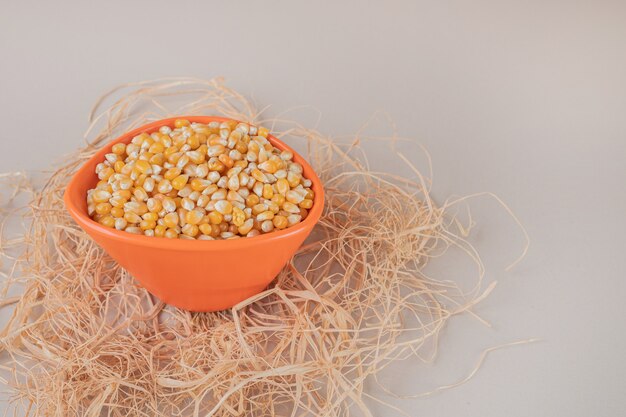 Corn seeds in a rustic on the grey concrete.