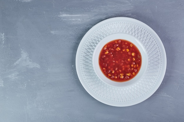 白い皿にトマトソースのコーンスープ。