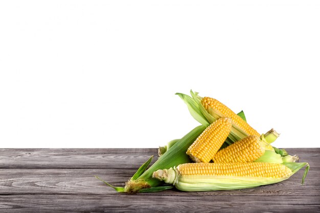 Corn on a wooden table isolated on white Premium Photo