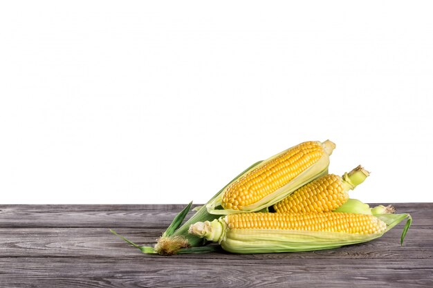 Corn on wooden table isolated on white Premium Photo