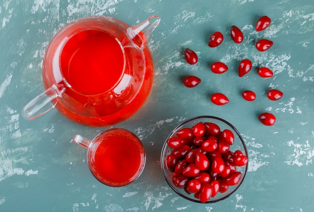 Cornel berries in a bowl with drink on plaster