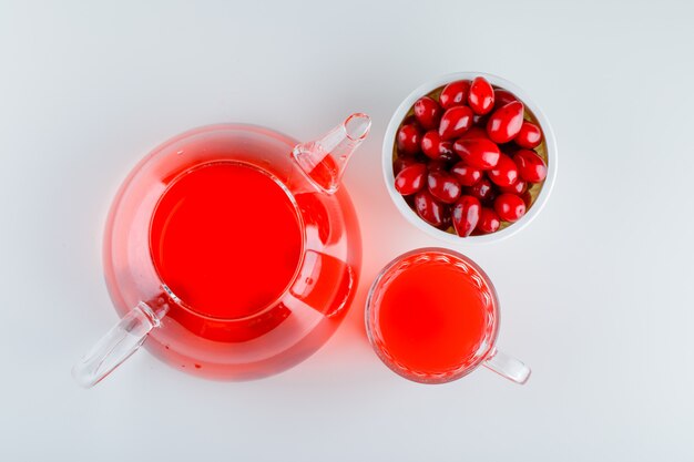 Cornel berries in a bowl with drink on white