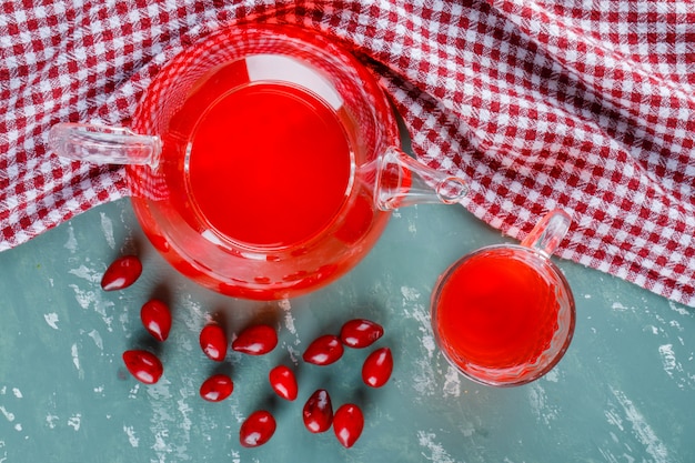 Bacche di corniolo con bevanda su intonaco e panno da picnic.