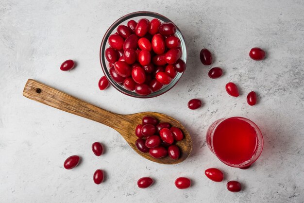 Cornel berries in a wooden spoon and juice in the glass. 