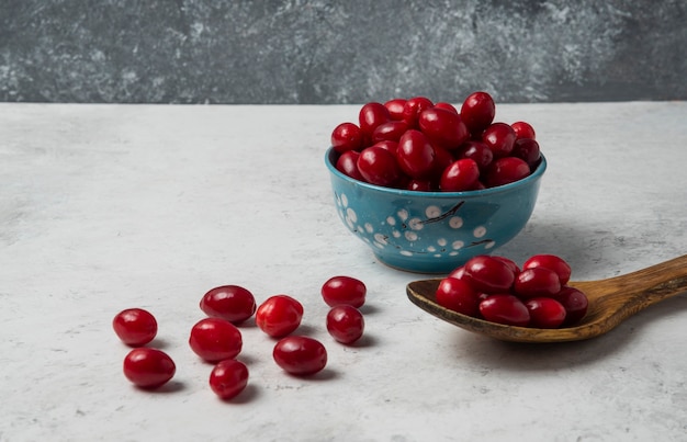 Free photo cornels in blue cup and a wooden spoon.