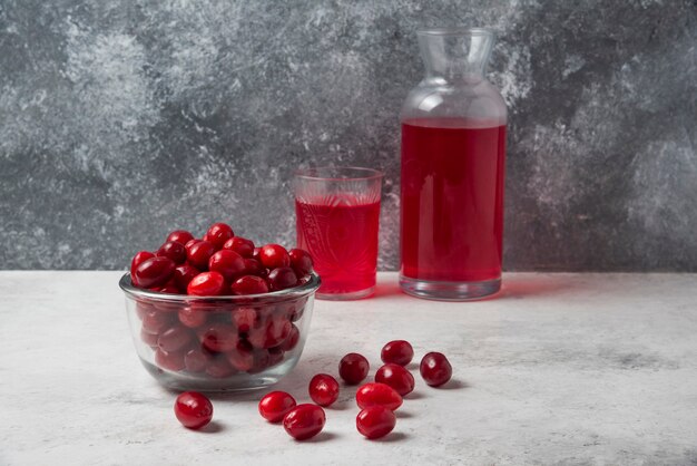 Cornels in a cup with a jar of juice. 