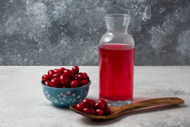 Cornels in a cup with a jar of juice. 