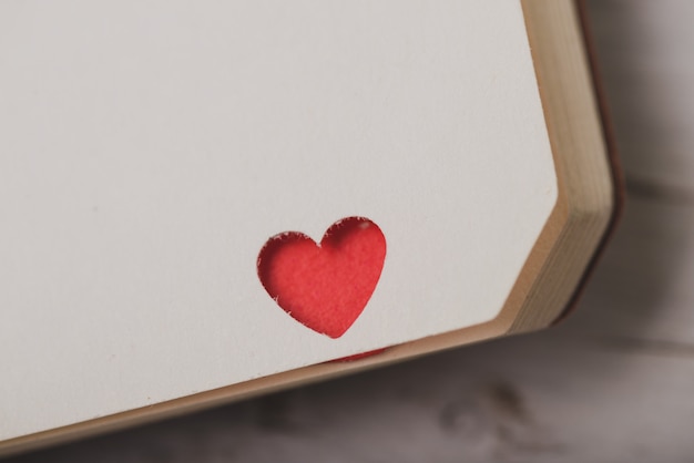 Foto gratuita angolo di un notebook con un cuore rosso