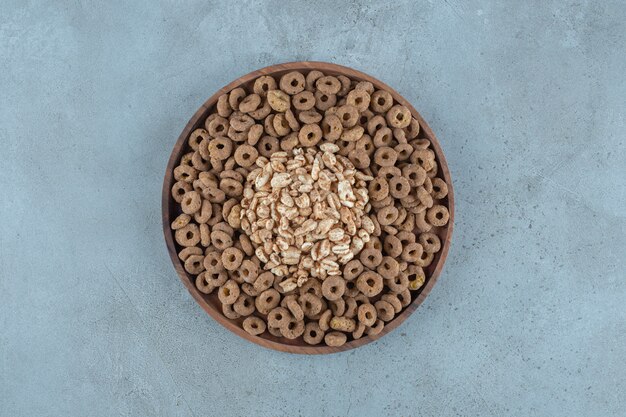 Cornflakes in the wooden plate , on the blue background. High quality photo