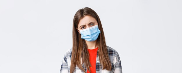 検疫の社会的距離と感情の概念に関するコロナウイルスの発生の余暇医療マスクの女性のクローズアップは、病気を捕まえるのが悪いと感じているか、夜勤の後に疲れています