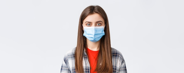 Free photo coronavirus outbreak leisure on quarantine social distancing and emotions concept closeup of young female student girl in medical mask looking at camera normal expression