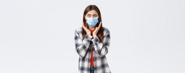 Coronavirus outbreak leisure on quarantine social distancing and emotions concept Concerned and shocked young woman hear bad news Girl in medical mask gasping and looking worried camera